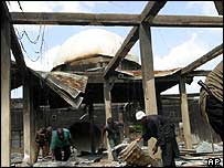 People clearing up damaged mosque