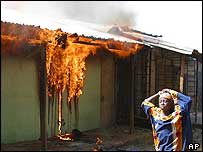 Girl walks past burning building in Yelwa