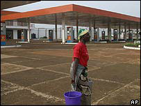Woman walks past deserted petrol station