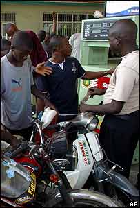 Nigerian two-wheel taxi drivers at fuel pump