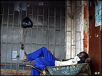 A worker sleeps in front of a closed shop in Abuja on 12 October
