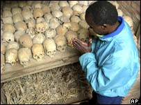 A survivor prays at a mass grave