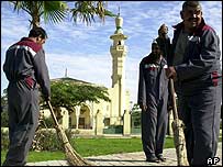 Workers clean street outside Cairo Airport's King Faisal bin Abdel Aziz Mosque 
